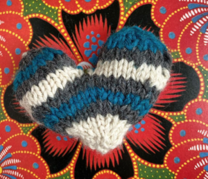 A knit heart on a colorful background by Jen O'Brien.