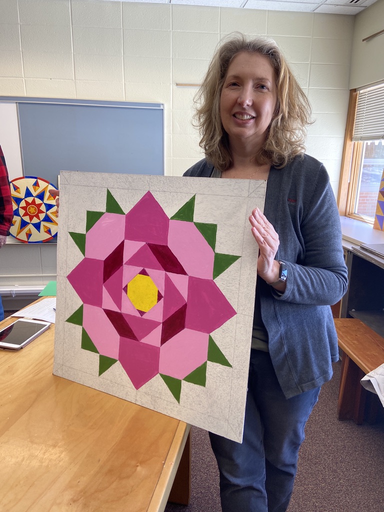 Janet Walker Beckman holds her barn hex sign