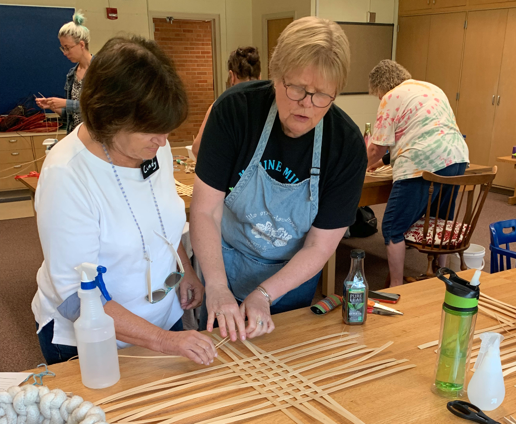 Kirsten Skoglund instructs a student in basket making