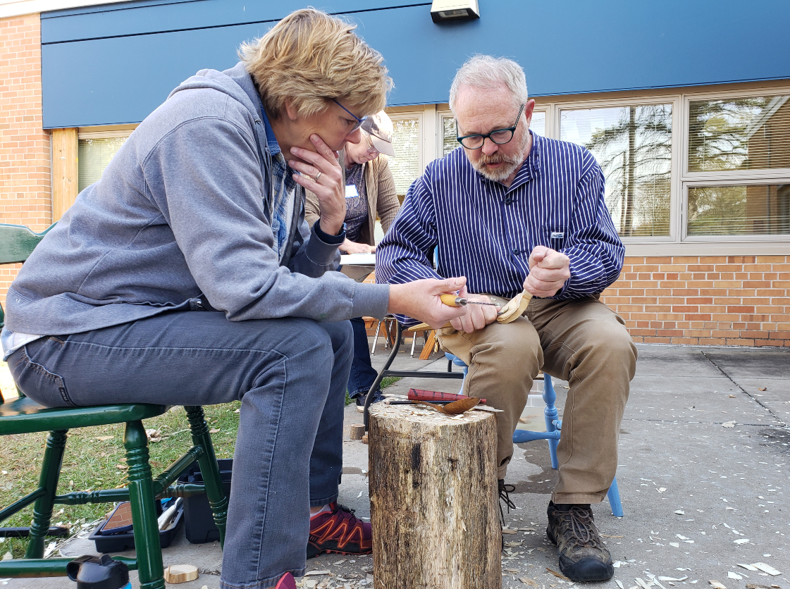 Fred livesay helps a student in advanced spoon carving