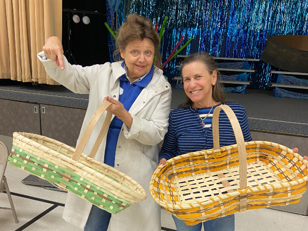 Two women display their completed Garden Trug Baskets at Marine Mills Folk School.