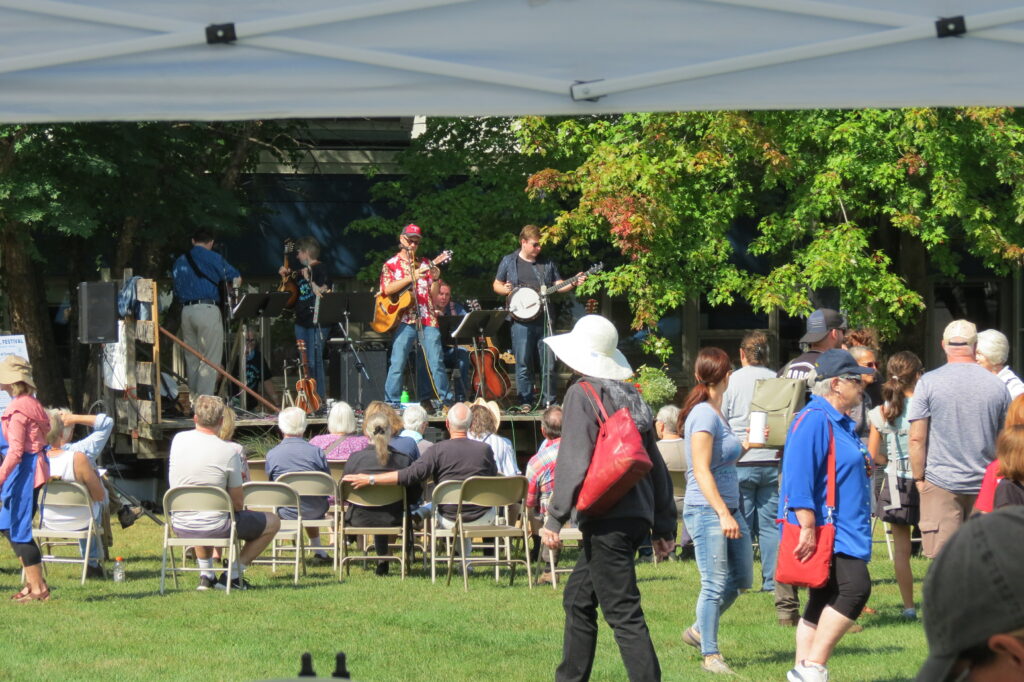 Bluegrass band North Shore Trail performs at the Marine Fall Festival at Marine Mills Folk School while a crowd watches.