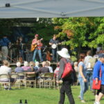 Bluegrass band North Shore Trail performs at the Marine Fall Festival at Marine Mills Folk School while a crowd watches.