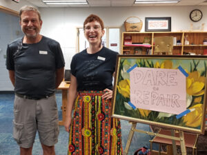 Dare to Repair volunteers Peter and Molly stand by their welcome sign