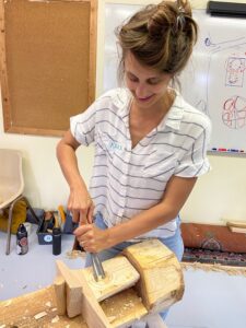 A woman carves a kuksa