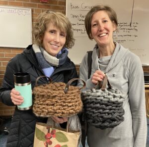 mom and daughter proudly display their completed crochet baskets