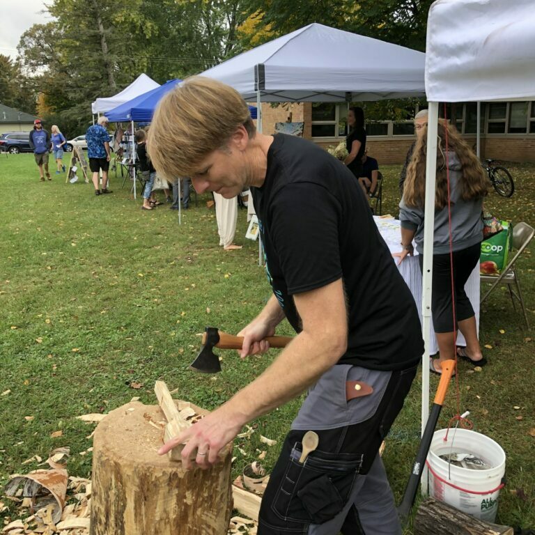Erik Vevang chopping a spoon with an axe at the Marine Fall Festival.